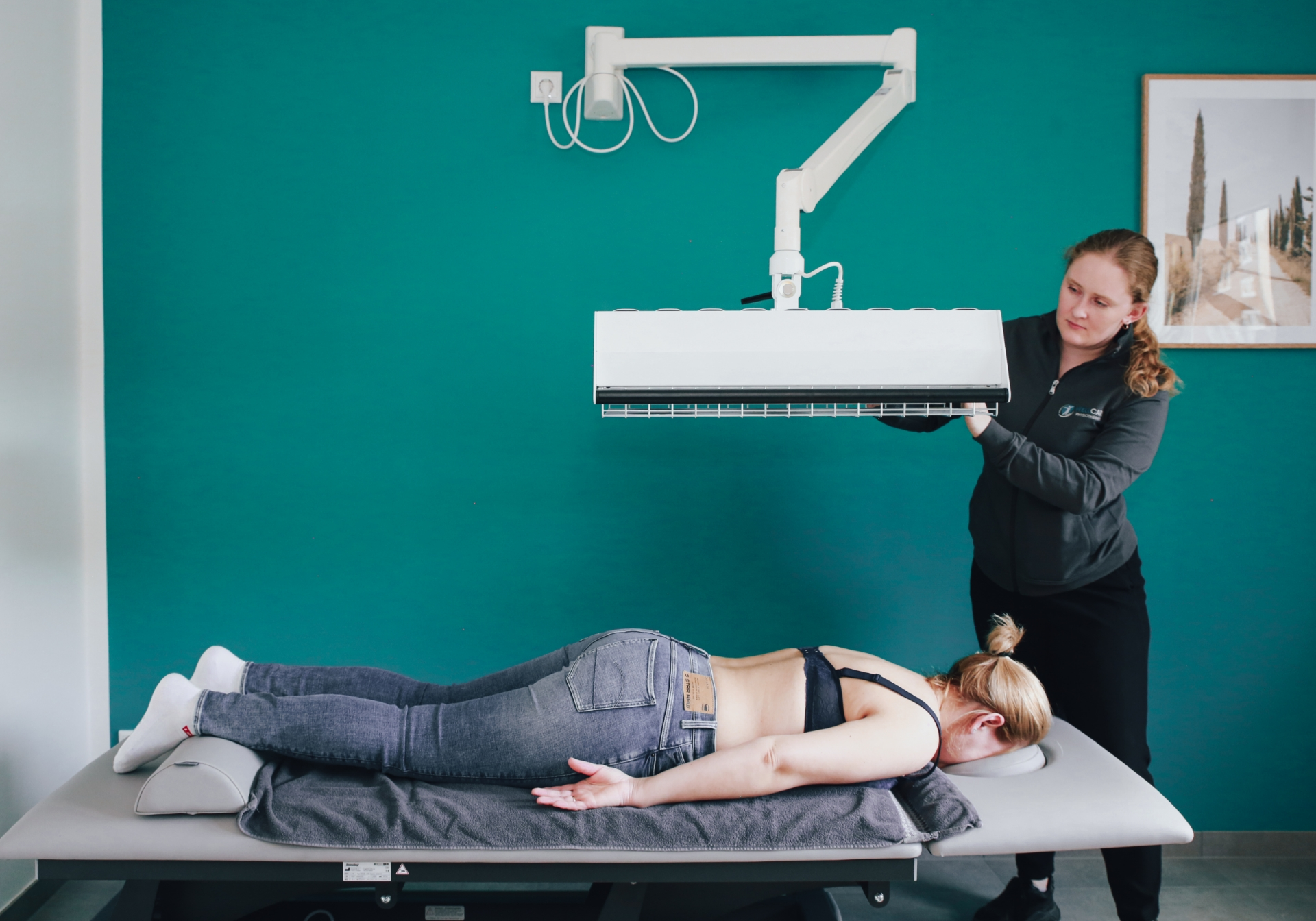 Nina Bollig macht eine Wärmetherapie bei einer Patientin auf dem Rücken